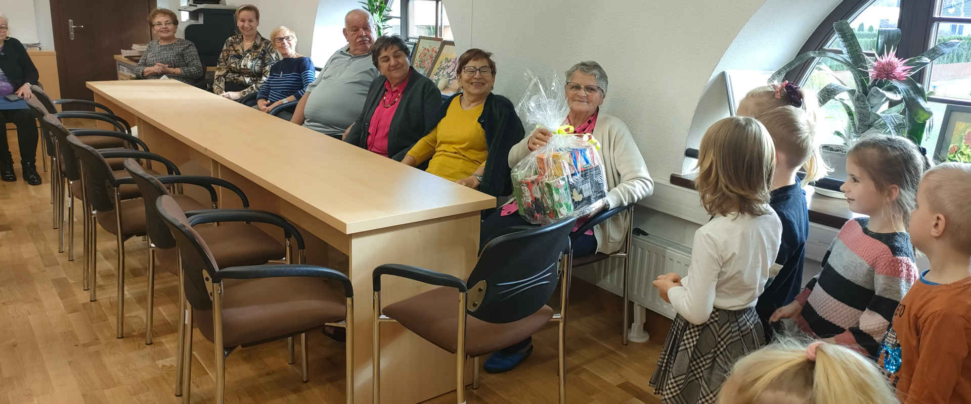 Dzieci wręczają prezenty seniorom