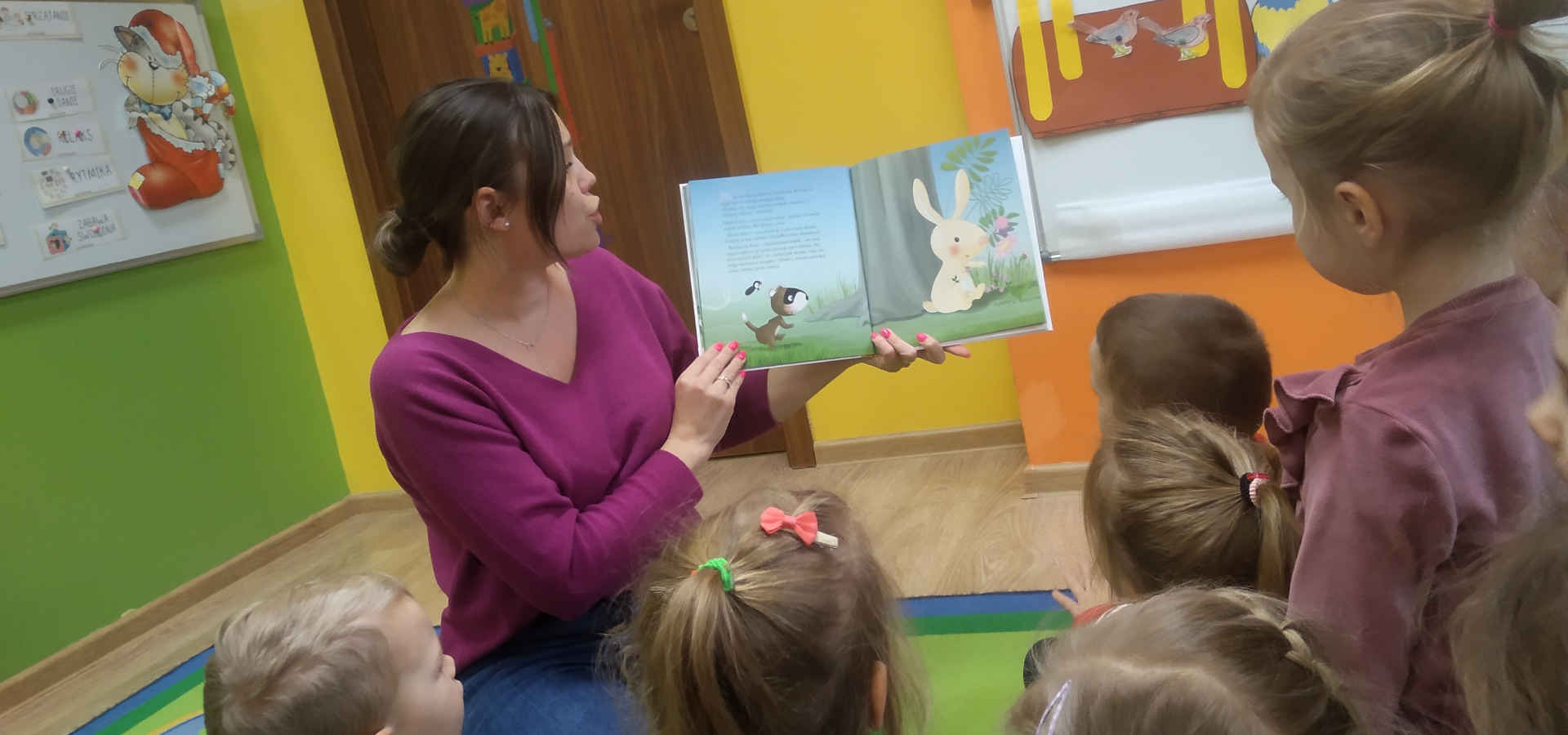 Opiekunka czyta dzieciom książkę