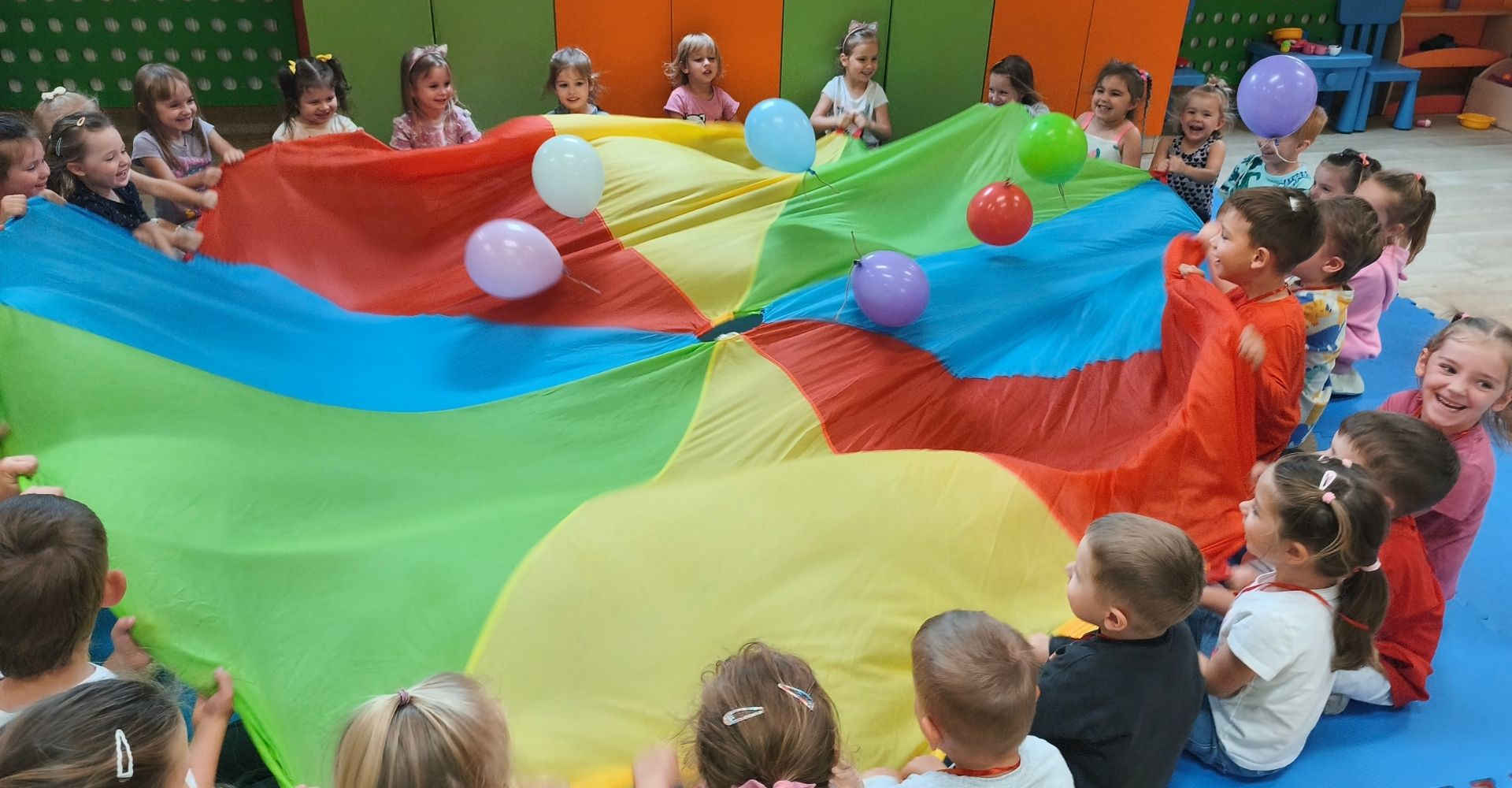 Dzieci podczas zabawy w kolorową chustą